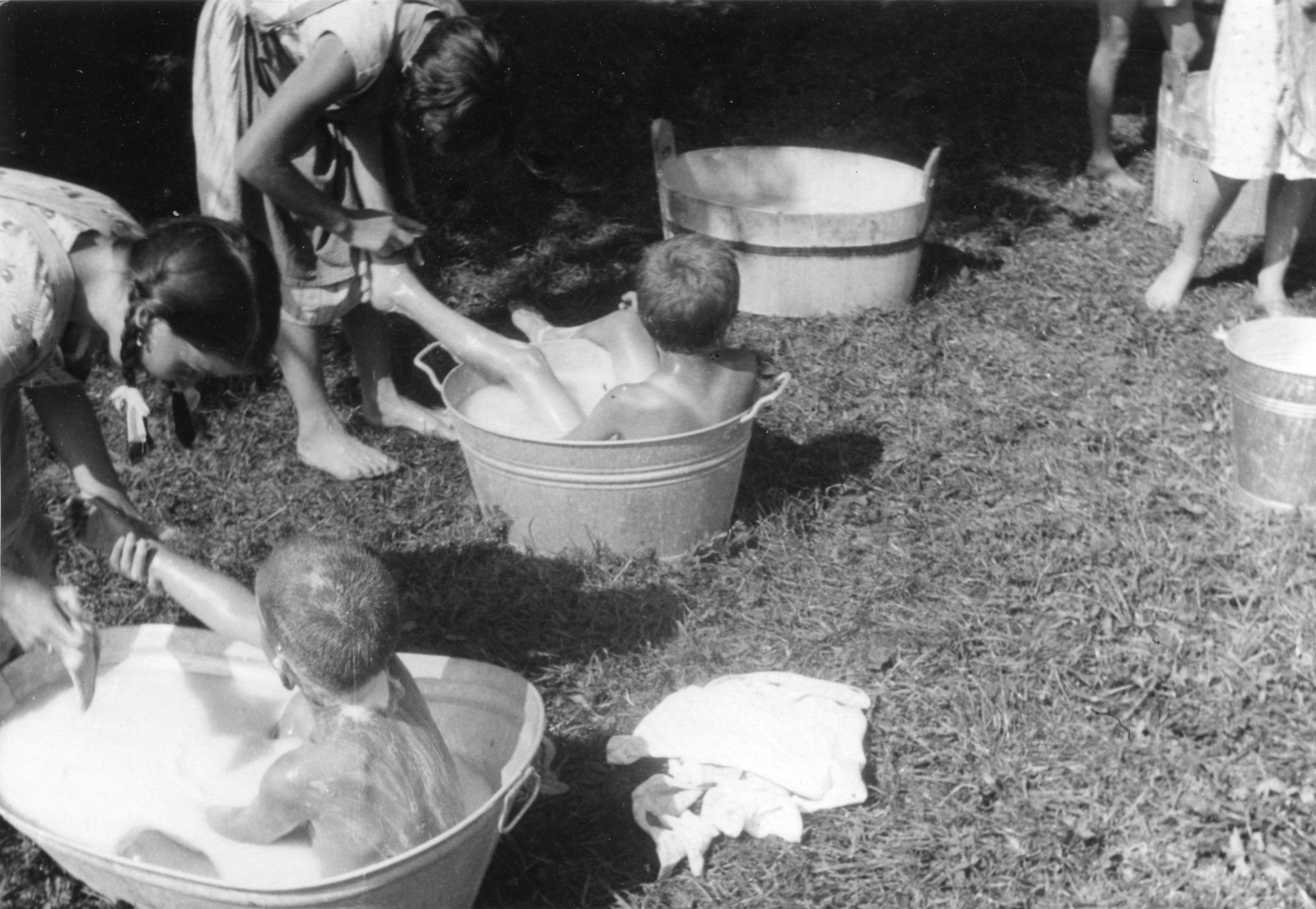 Betreuerinnen waschen die kleinen Kinder in einem Trog