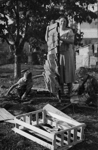 Spielplatz - Mutter und zwei Kinder beim Bauen einer Bretterwand; um 1965