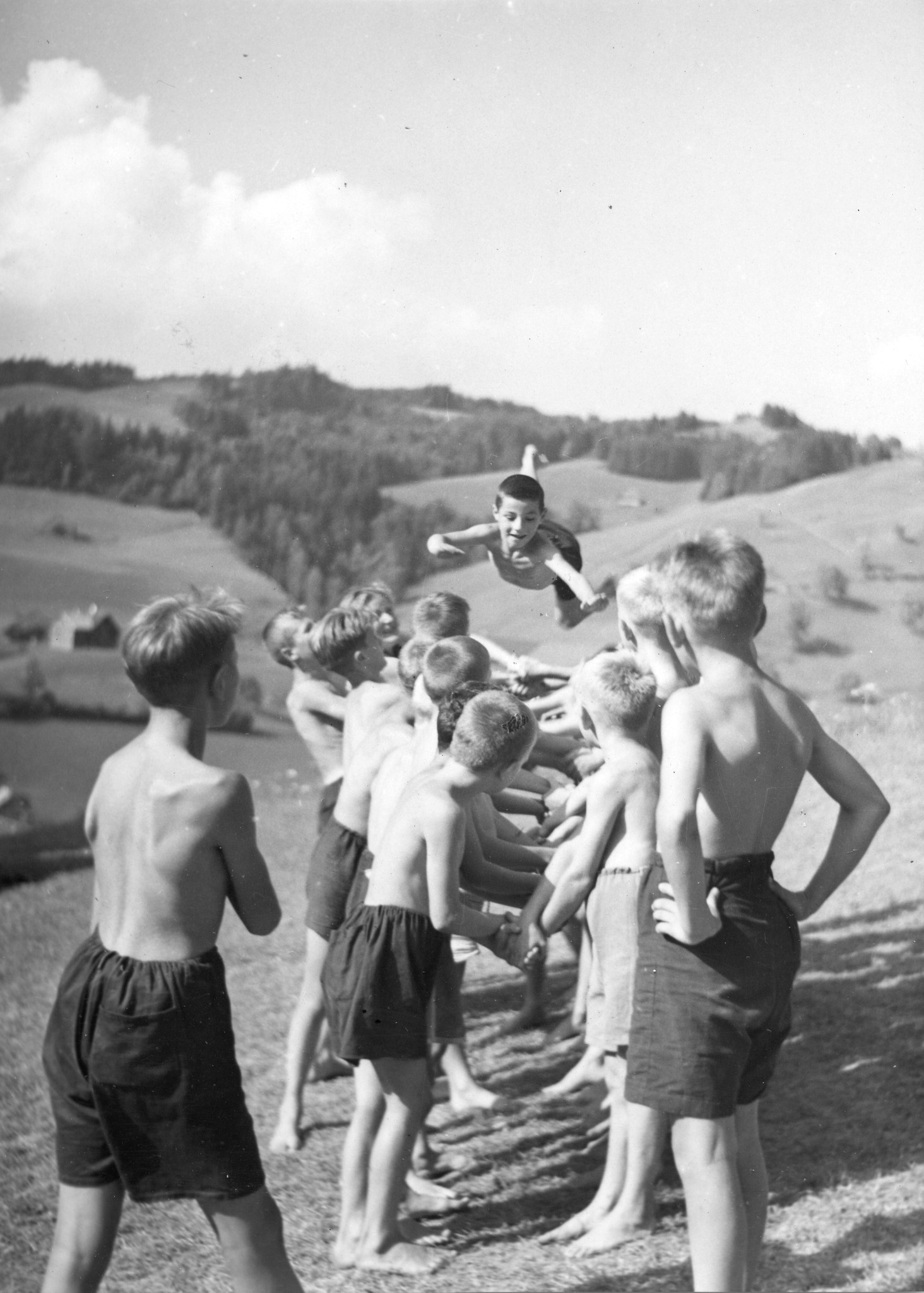 Knaben lassen einen Freund während eines Spiels durch die Luft fliegen