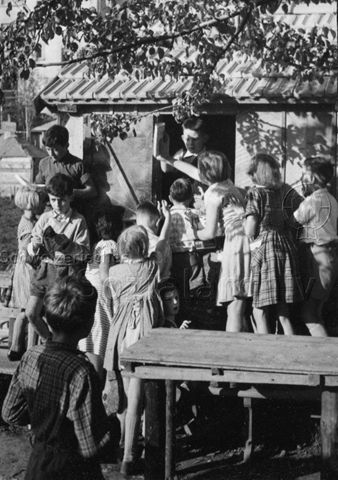 Spielplatz - Kinder bei der Ausgabe von Heften; um 1965